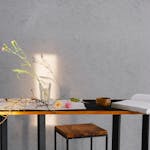 A minimalist scene of a table with flowers, an open book, and wooden bowl, enhanced by natural lighting.